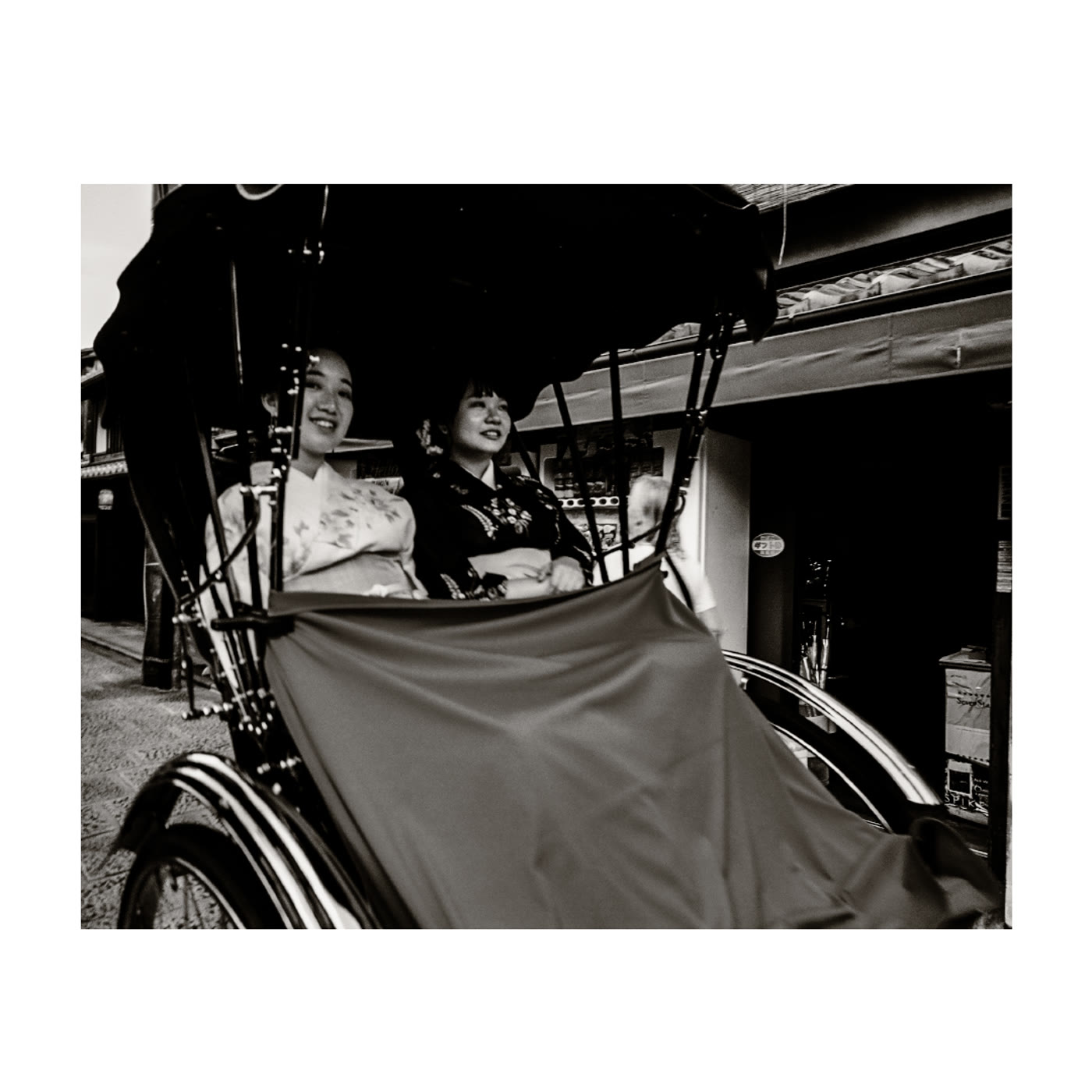 Two women in kimono riding a rickshaw · photograph by Jeff Smith